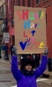 Young person with poster that says: Should have let us vote